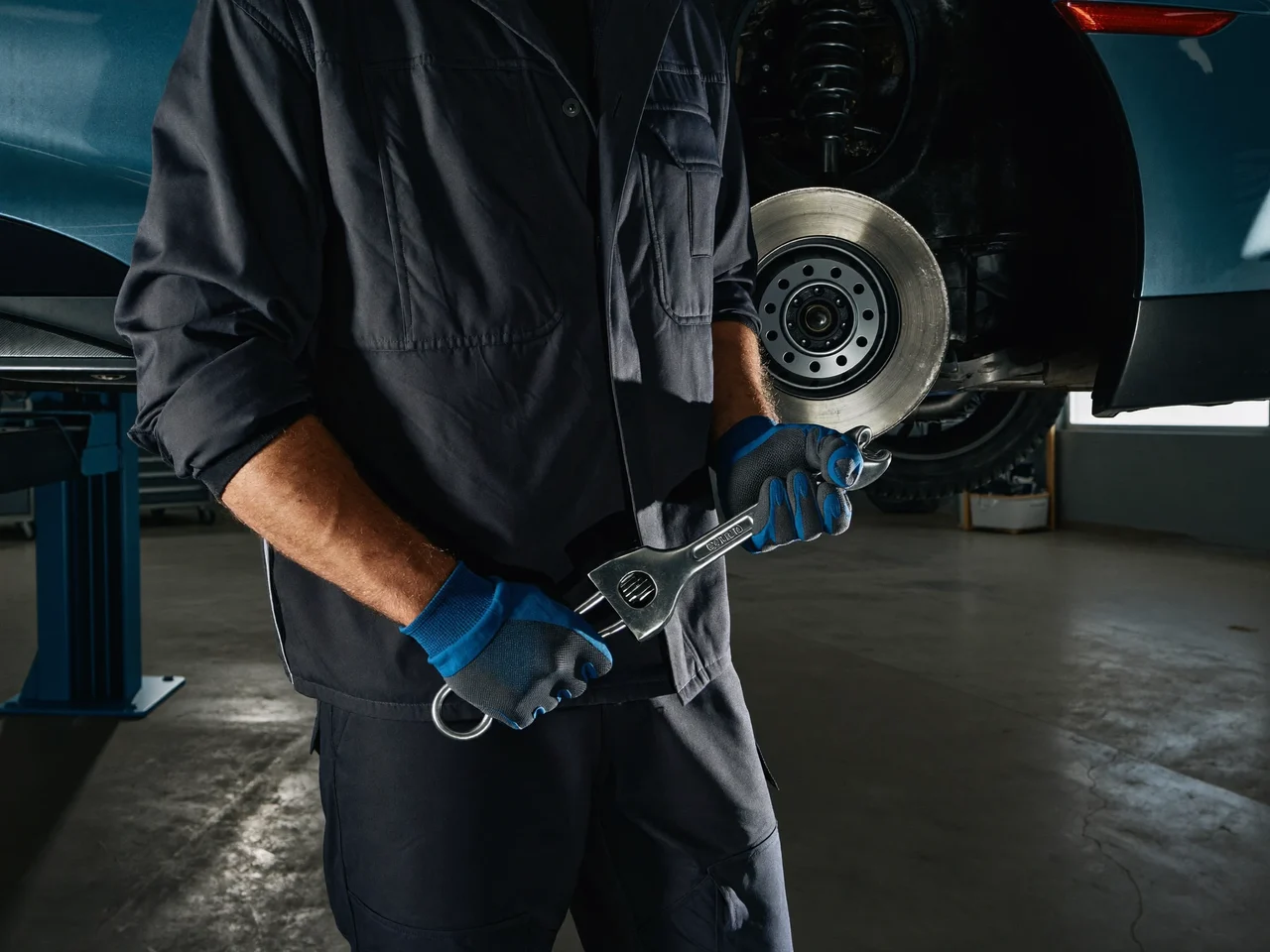Mecanic care desface o piuliță de roată cu pistolul pneumatic