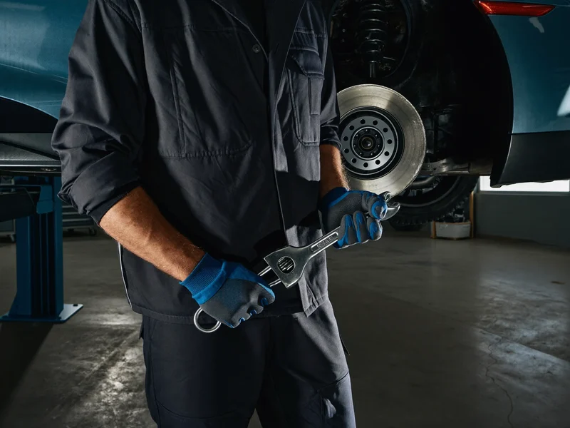 Mecanic care desface o piuliță de roată cu pistolul pneumatic